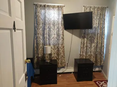 a living room with two curtains and a television at 1052grovest #3 in Irvington