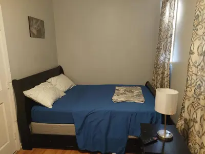a small bedroom with a blue bed and a lamp at 1052grovest #3 in Irvington