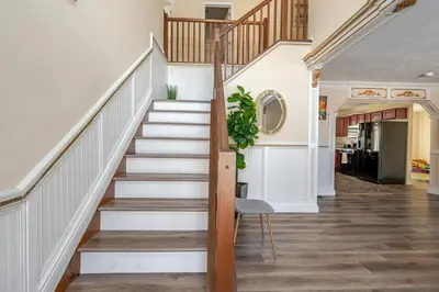a staircase in a home with white walls and wooden railings at Boulders Retreat Hot Tub Sauna Game Room Fire Pit in Tobyhanna