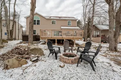 a yard with three chairs and a fire pit in front of a house at Boulders Retreat Hot Tub Sauna Game Room Fire Pit in Tobyhanna
