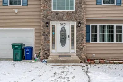 a front door of a house with snow on the ground at Boulders Retreat Hot Tub Sauna Game Room Fire Pit in Tobyhanna