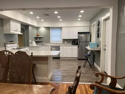 a kitchen with white cabinets and a large island at Pleasant, Comfortable PR Near Vestal NY in Johnson City