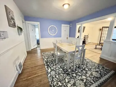 a dining room with a table and chairs on a rug at Binghamton Hospitals Private Room Shared Spaces Trades Medical Staff Welcom in Binghamton