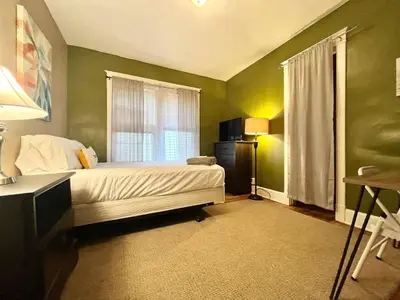 a bedroom with green walls and a bed and a window at Affordable for Crews Binghamton Close to Job Sites in Binghamton