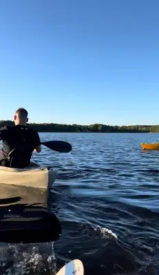 a man is sitting in a boat on the water at Home in Mount Pocono - Sauna & Lakefront in Pocono Summit