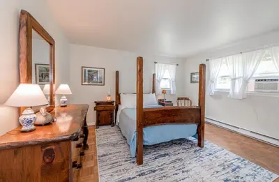 a bedroom with a large bed and a mirror at Catskill gem! Four bedroom on 20 quiet acres in Barryville