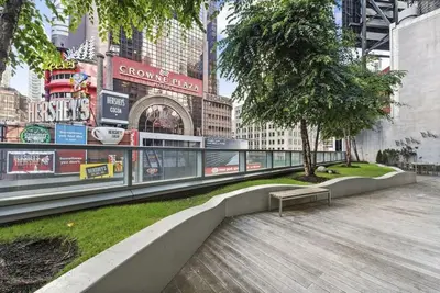 a park with a bench in the middle of a city at 1600 Broadway in New York
