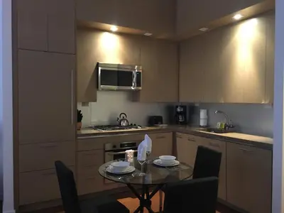 a small kitchen with a table and a microwave at 1600 Broadway in New York