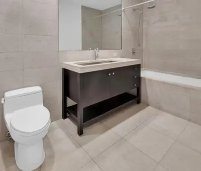 a bathroom with a toilet and a sink and a mirror at 1600 Broadway in New York