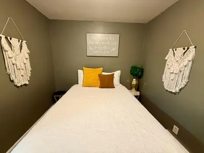a bedroom with a large bed with yellow pillows at Happy House in the City in Harrisburg