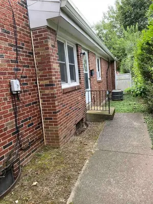 a brick house with a porch and a sidewalk at Happy House in the City in Harrisburg