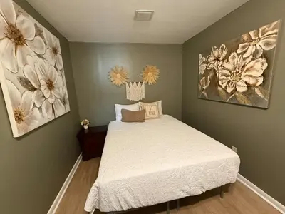 a bedroom with a bed and two paintings on the wall at Happy House in the City in Harrisburg