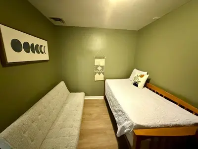 a green room with two beds and a couch at Happy House in the City in Harrisburg