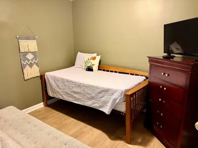 a small bedroom with a bed and a dresser at Happy House in the City in Harrisburg