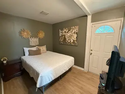 a bedroom with a bed and a tv and a door at Happy House in the City in Harrisburg