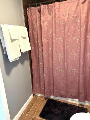a pink shower curtain in a bathroom with towels at 5 bedrooms 2 bathrooms furnished home in Philly near Temple University in Philadelphia