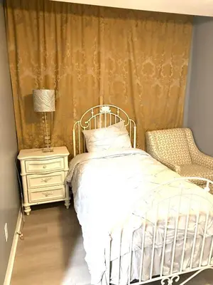 a bedroom with a bed and a lamp and a chair at 5 bedrooms 2 bathrooms furnished home in Philly near Temple University in Philadelphia