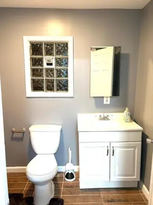 a bathroom with a toilet and a sink and a window at 5 bedrooms 2 bathrooms furnished home in Philly near Temple University in Philadelphia