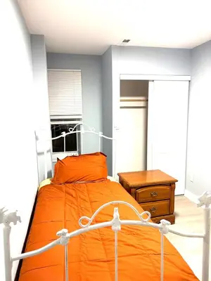 a bedroom with an orange bed and a wooden table at 5 bedrooms 2 bathrooms furnished home in Philly near Temple University in Philadelphia