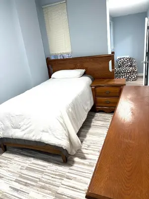 a bedroom with a bed and a wooden table at 5 bedrooms 2 bathrooms furnished home in Philly near Temple University in Philadelphia