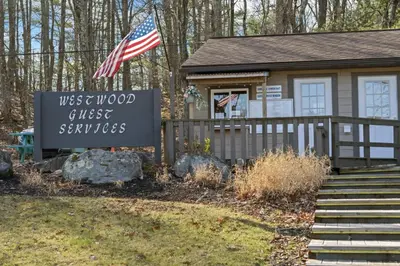 a sign in front of a small house with a flag at Westwood Villas by Coolvacay in Lake Harmony