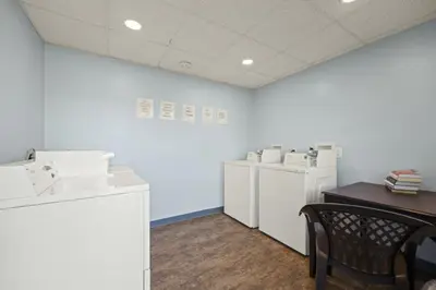 a laundry room with white appliances and a table and chairs at Westwood Villas by Coolvacay in Lake Harmony