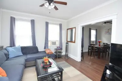 a living room with a blue couch and a table at Cozy Beds with Parking, Laundry - Near RU, RWJ, NJ Transit in Highland Park