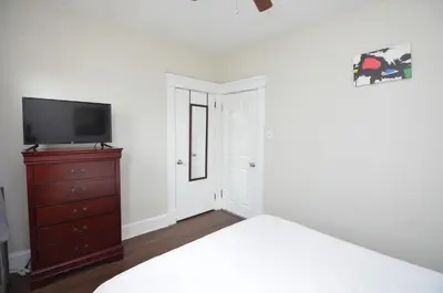 a bedroom with a bed and a tv and a dresser at Cozy Beds with Parking, Laundry - Near RU, RWJ, NJ Transit in Highland Park