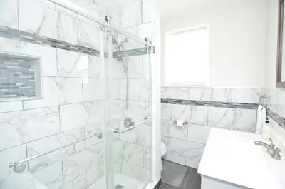 a white bathroom with a glass shower stall and a sink at Cozy Beds with Parking, Laundry - Near RU, RWJ, NJ Transit in Highland Park