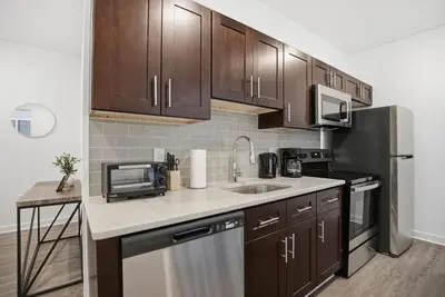 a kitchen with a sink and a refrigerator at Cozy 1BR home inside the Fairmount Square building in Philadelphia