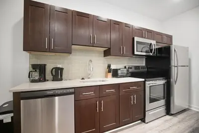 a kitchen with wooden cabinets and a stainless steel refrigerator at Modern 1BR1BA unit at Fairmount Square in Philadelphia