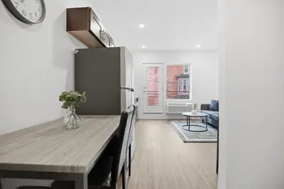 a kitchen and dining room with a table and a clock at Bright 1BR unit in the Fairmount Square building in Philadelphia
