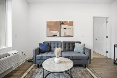 a living room with a blue couch and a table at Bright 1BR unit in the Fairmount Square building in Philadelphia