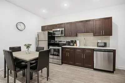 a kitchen with wooden cabinets and a table with chairs at Contemporary 1BR inside Fairmount Square in Philadelphia