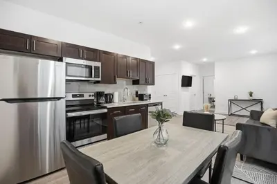 a kitchen and dining room with a wooden table and a kitchen with at Refreshed 1BR1BA in Fairmount Square in Philadelphia