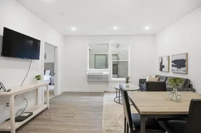 a living room with a television and a dining table at Cozy and bright 1BR located in Fairmount Square in Philadelphia