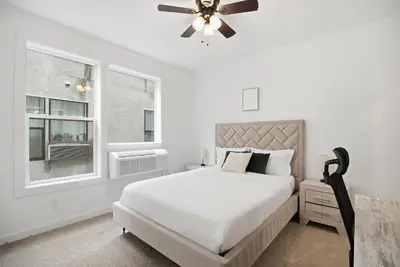 a white bedroom with a bed and a ceiling fan at Simple, modern 1BR in Fairmount Square in Philadelphia