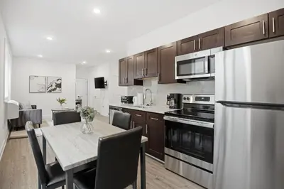a kitchen with a dining table and a kitchen with a refrigerator at Simple, modern 1BR in Fairmount Square in Philadelphia