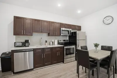 a kitchen with wooden cabinets and a table with chairs at Attractive 1BR1BA apartment at Fairmount Square in Philadelphia