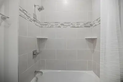 a white bathroom with a tub and a shower at Comfortable updated 1BR in Fairmount Square in Philadelphia