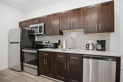 a kitchen with brown cabinets and a white counter top at Bright and cozy 1BR inside Fairmount Square in Philadelphia