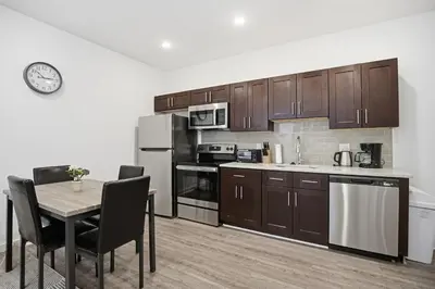 a kitchen with wooden cabinets and a table with chairs at Bright and cozy 1BR inside Fairmount Square in Philadelphia