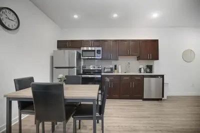 a kitchen with wooden cabinets and a table and chairs at Bright and cozy 1BR inside Fairmount Square in Philadelphia