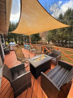 a patio with a table and chairs and a large umbrella at Huge Private Suite with Pool Table, Sauna & Fire Pit in Ellenville