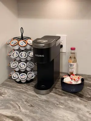 a coffee maker on a counter next to a plate of cupcakes at Huge Private Suite with Pool Table, Sauna & Fire Pit in Ellenville