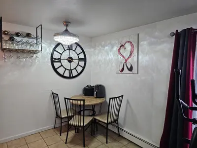 a dining room with a table and a clock on the wall at Clientele in North Bergen