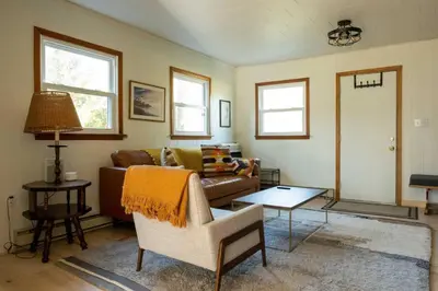 a living room with a couch and a table at Riverfront Poconos Cabin with Hot Tub on 4 Acres Near Delaware River (Sleeps 6) in Lackawaxen