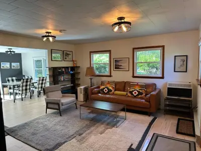 a living room with a couch and a table at Riverfront Poconos Cabin with Hot Tub on 4 Acres Near Delaware River (Sleeps 6) in Lackawaxen