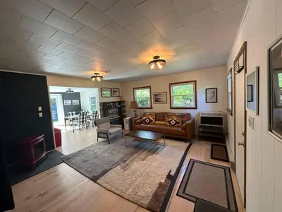 a living room with a couch and a table at Riverfront Poconos Cabin with Hot Tub on 4 Acres Near Delaware River (Sleeps 6) in Lackawaxen