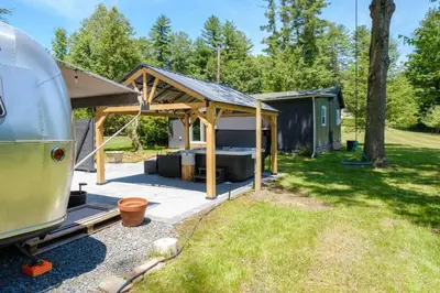 a rv parked in a yard with a tent at Riverfront Poconos Cabin with Hot Tub on 4 Acres Near Delaware River (Sleeps 6) in Lackawaxen